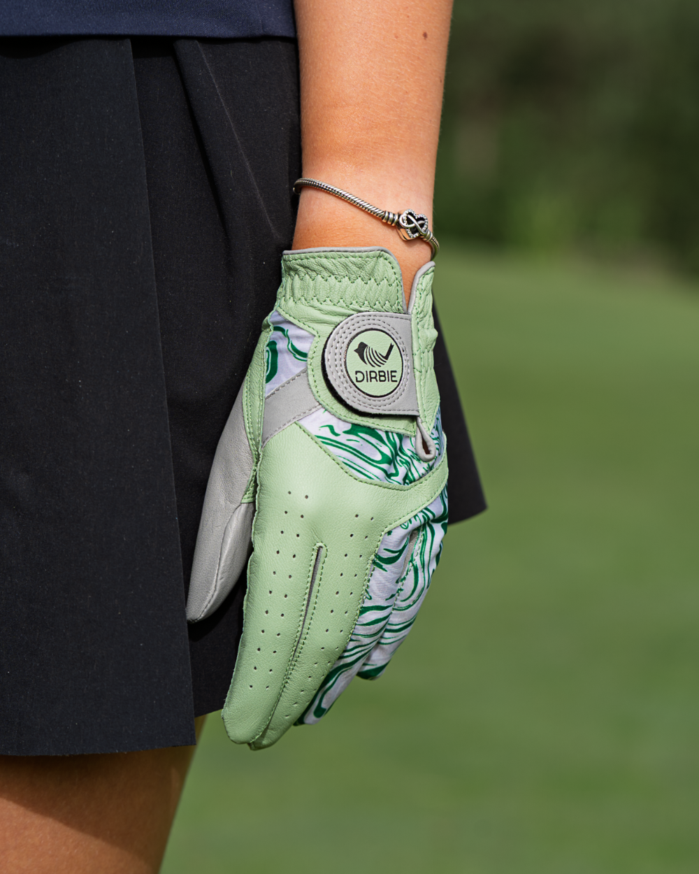 A smoke green Dirbie Trinix Ladies golf glove with green and white floral patterns, worn on a person&